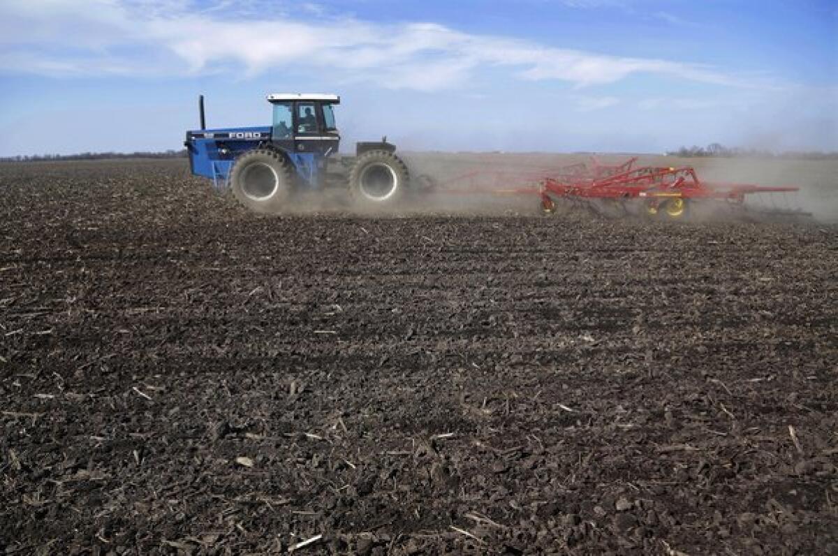 A central Illinois corn and soybean farmer cultivates his field in preparation for spring planting.
