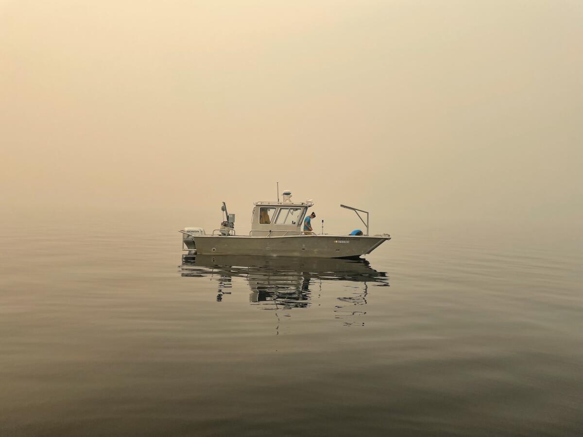 A boat floats amid a haze of smoke.