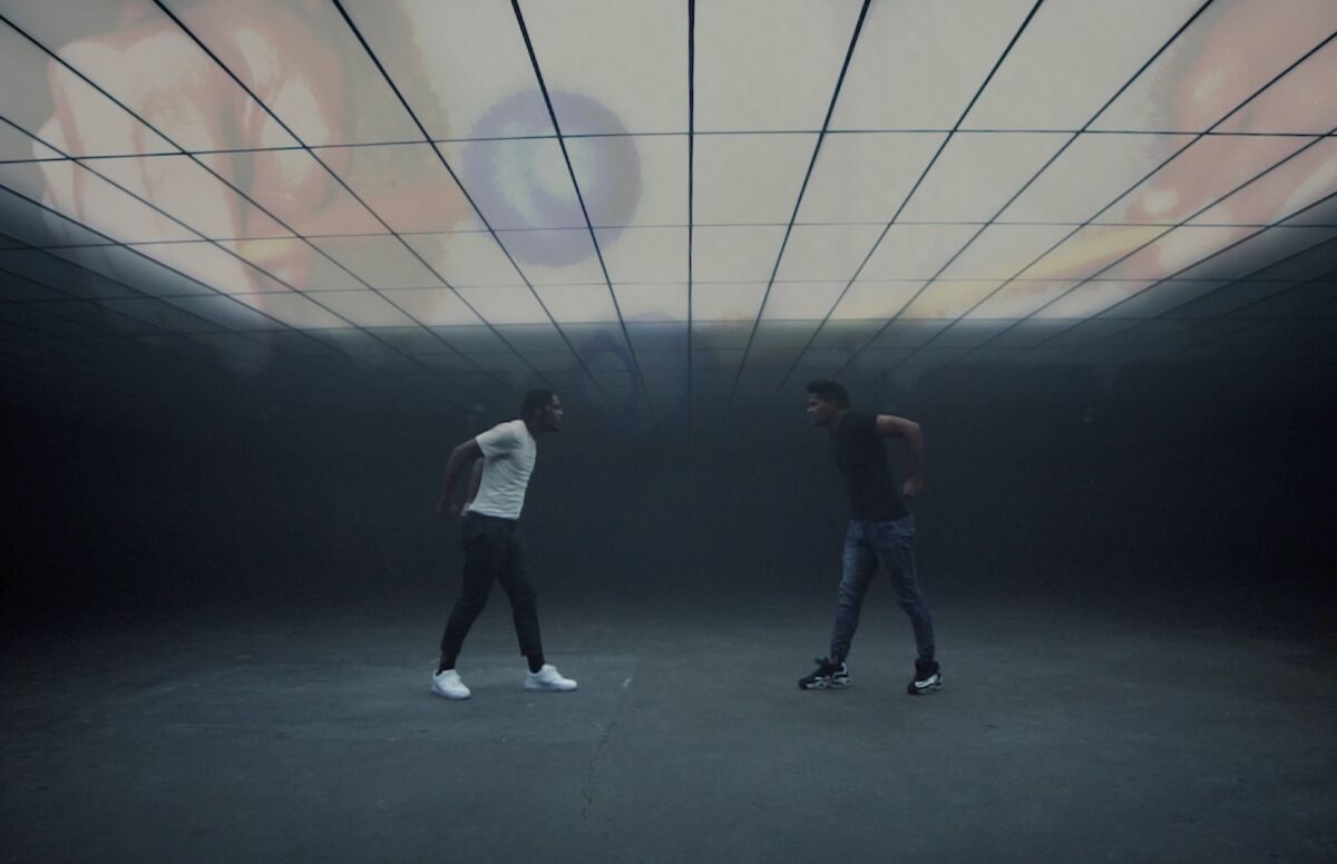 A scene from the "Metamorphosis" promotional video shows movement artists performing.
