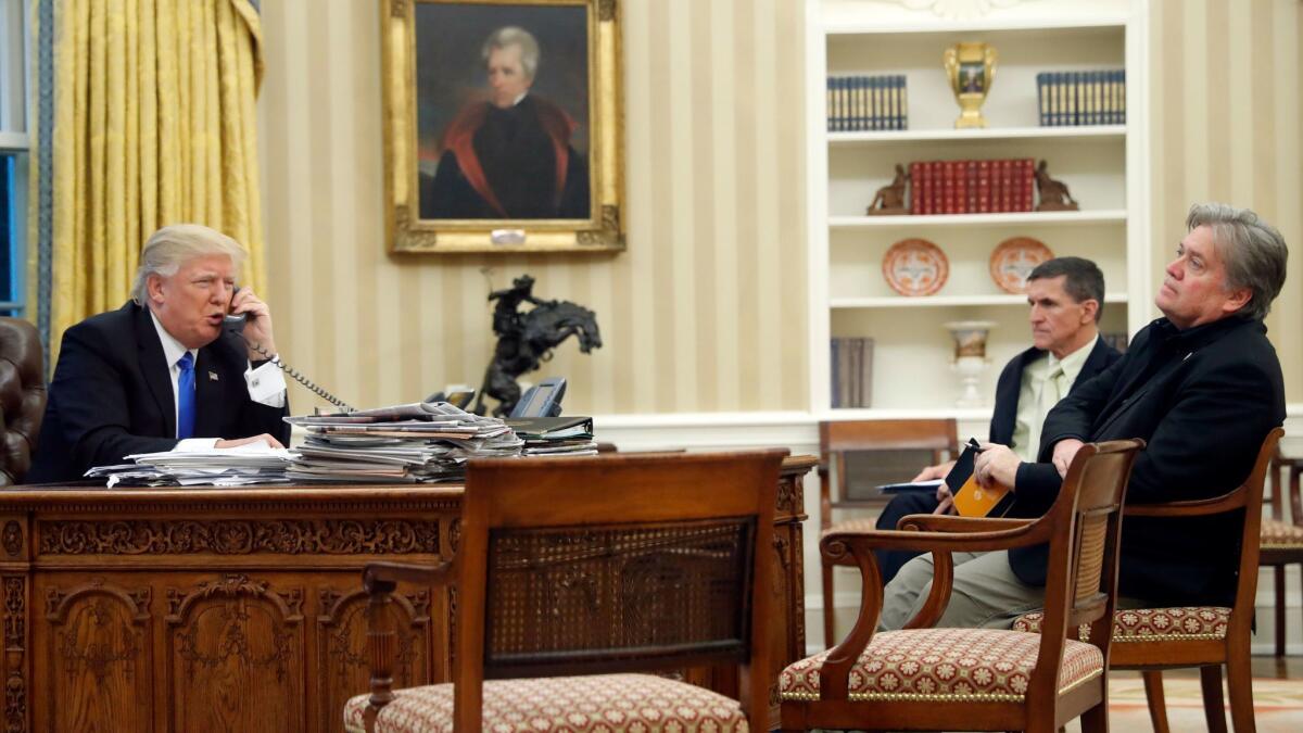 President Trump with then-chief strategist Steve Bannon, right, and then-national security advisor Michael Flynn, in the Oval Office on Jan. 28, 2017.