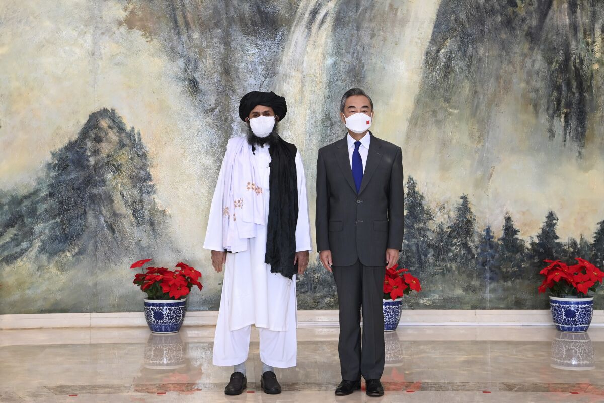 Taliban co-founder Mullah Abdul Ghani Baradar, left, and Chinese Foreign Minister Wang Yi meet in Tianjin, China.