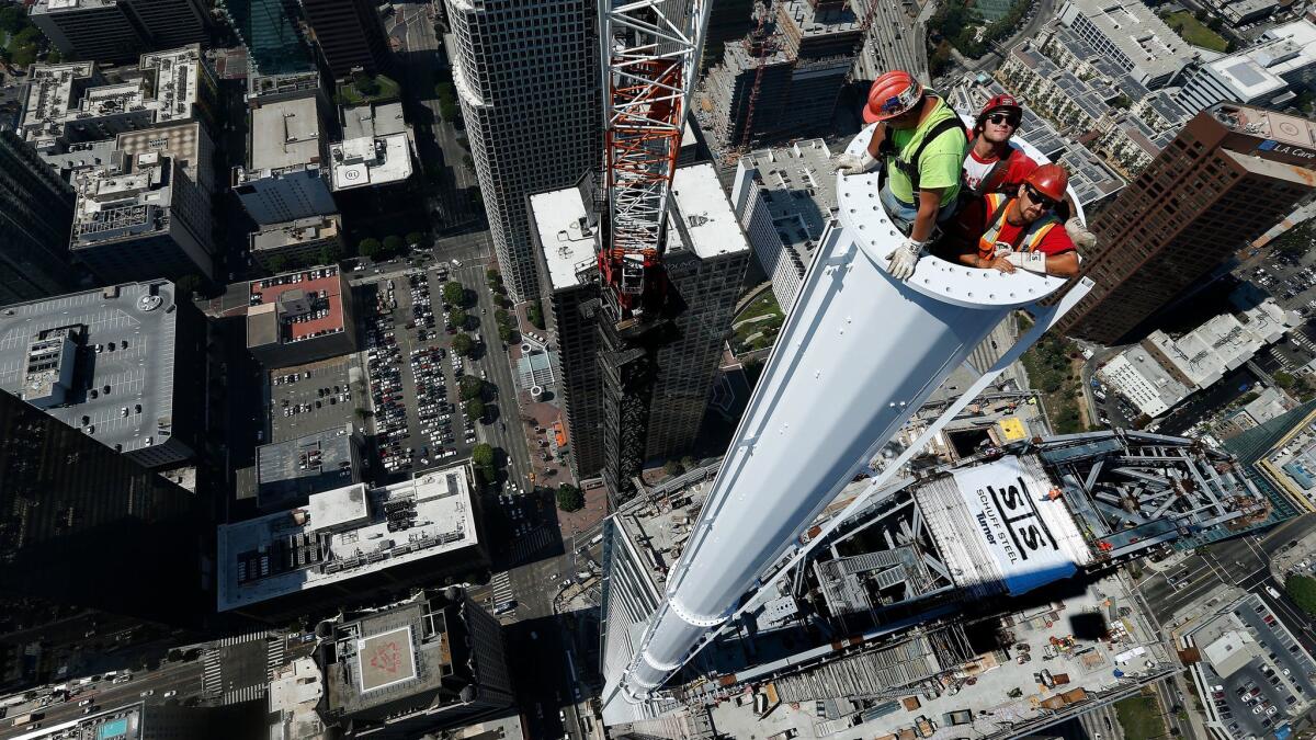 Iron workers perch atop the Wilshire Grand Center in September. With its spire in place, the downtown L.A. building will be the tallest west of the Mississippi.