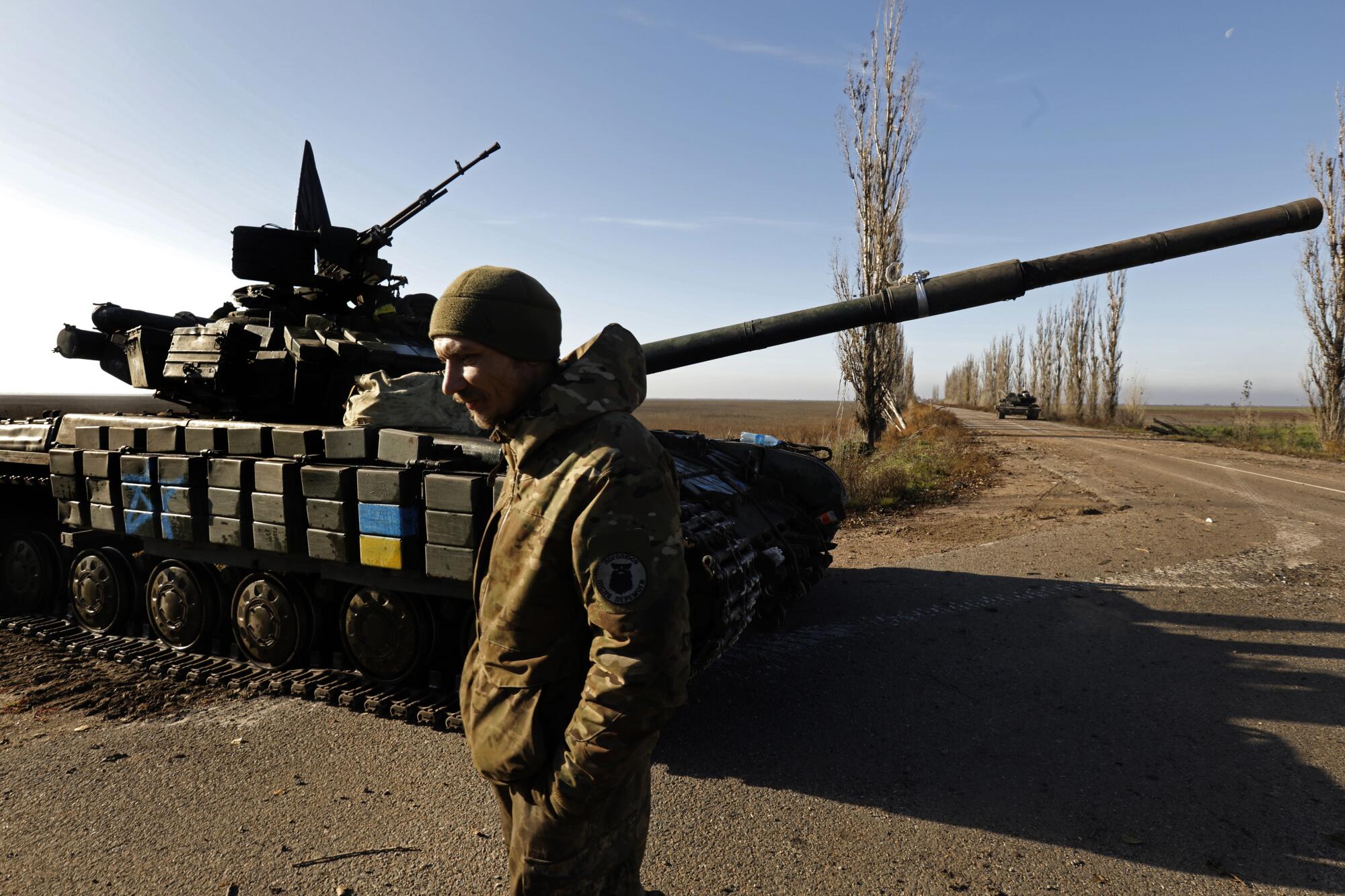 A Ukrainian Army tank platoon waits on the side of the road after one of their tanks hit a mine and was blown off the road.