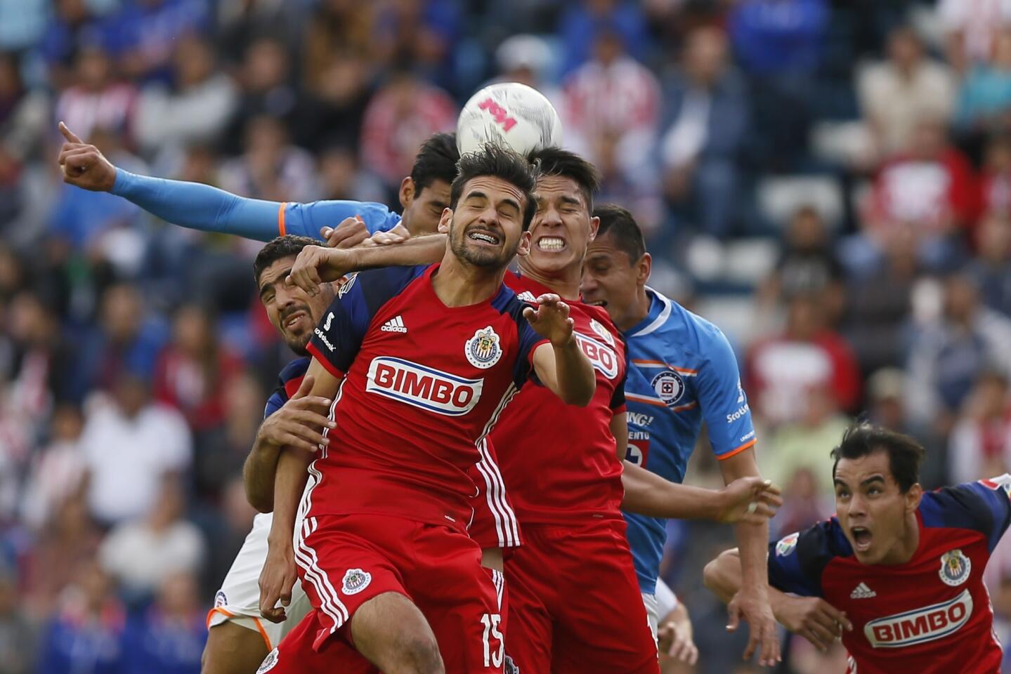 Los jugadores de Chivas Raúl López (frente) y Carlos Salcedo (d) disputan el balón con Jorge Benítez (atrás izq.) y con Aldo Ramírez (atrás der.) de Cruz Azul, en partido de la jornada 2 del Torneo Clausura del futbol mexicano, realizado en el estadio Azul, en Ciudad de México.