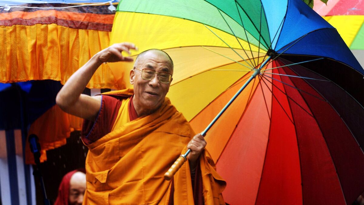 Tibetan spiritual leader the Dalai Lama greets people in Huy, Belgium on May 29, 2006.