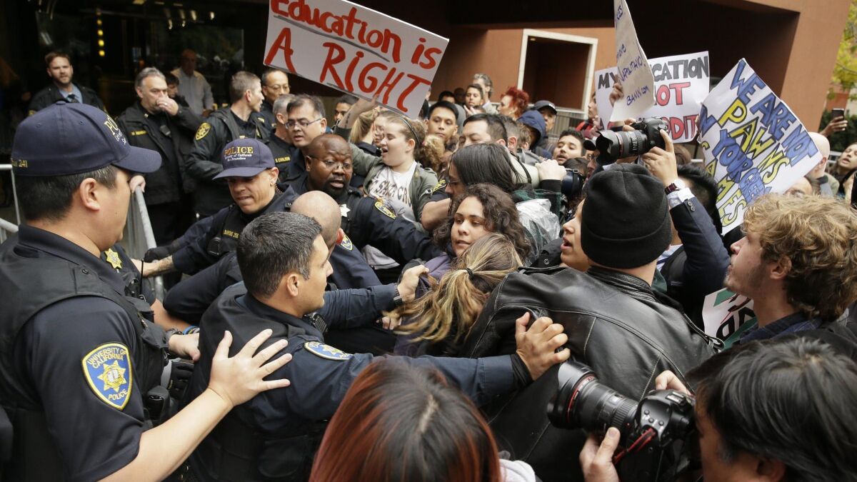 UC police push student protesters back behind barricades outside a meeting of the Board of Regents on Nov. 19, 2014.