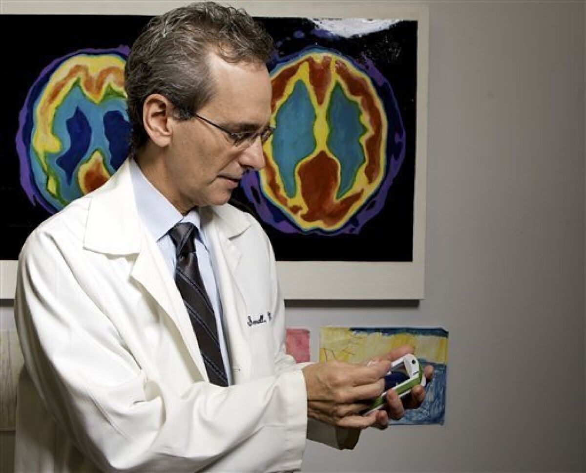 University of California, Los Angeles, Professor of Psychiatry Dr. Gary Small plays with a digital memory electronic device at his office at the Semel Institute for Neuroscience & Human Behavior in Westwood, Calif., on Monday, Dec. 1, 2008. (AP Photo/Damian Dovarganes)