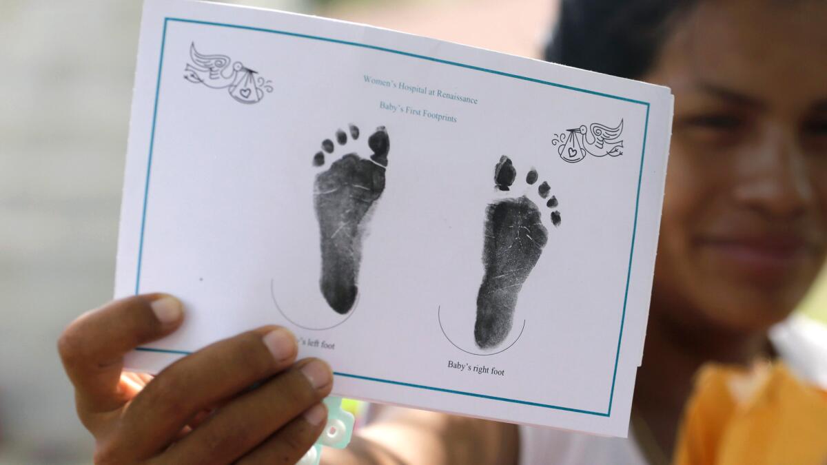 A woman in Sullivan City, Texas, who said she entered the country illegally shows the footprints of her daughter, who was born in the United States but was denied a birth certificate.