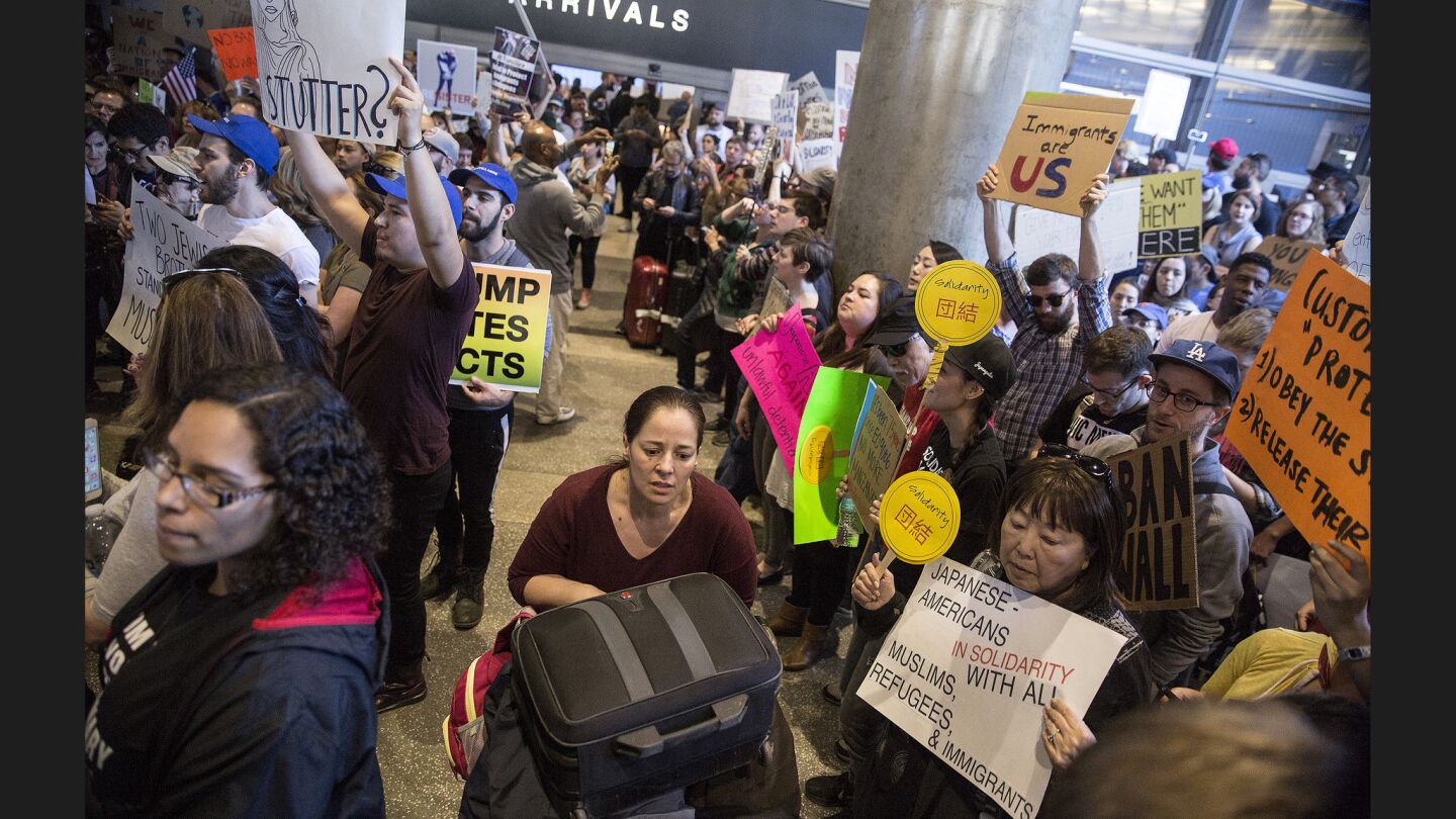A traveler tries to get by protesters at Tom Bradley International Terminal.