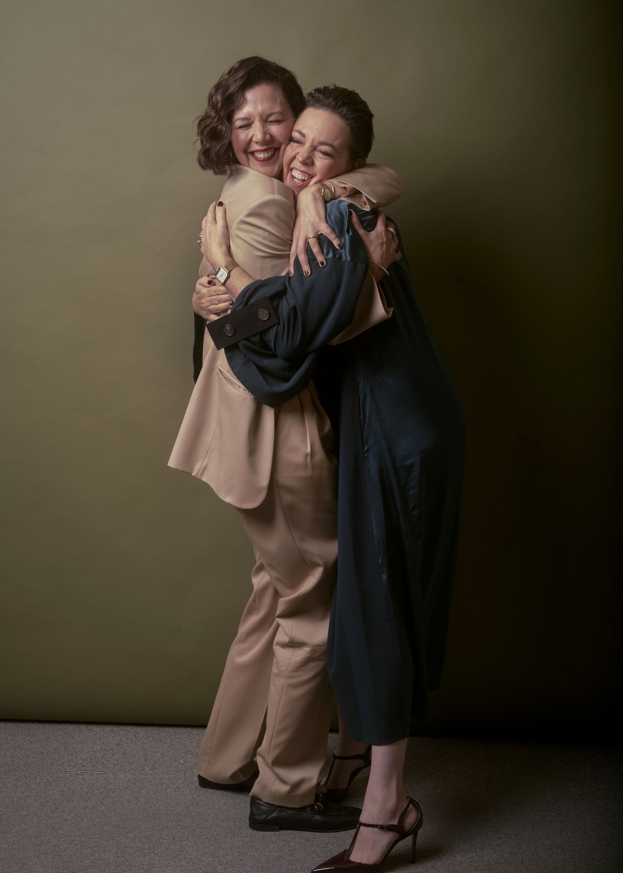 Maggie Gyllenhaal and Olivia Colman embrace.