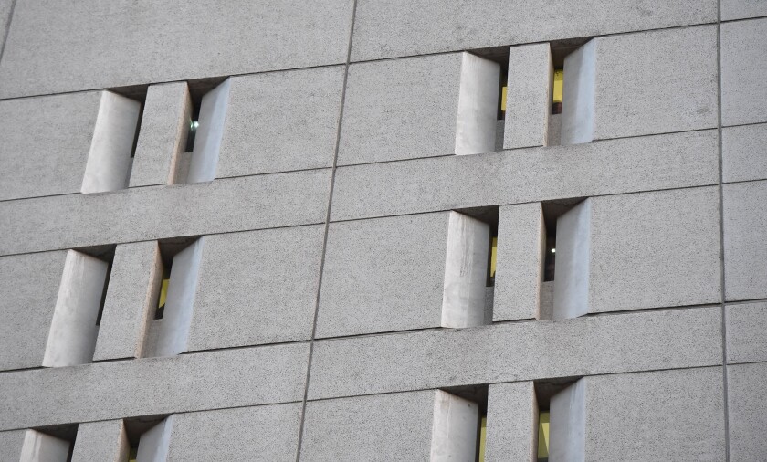 Narrow windows in the side of a brutalist concrete prison building