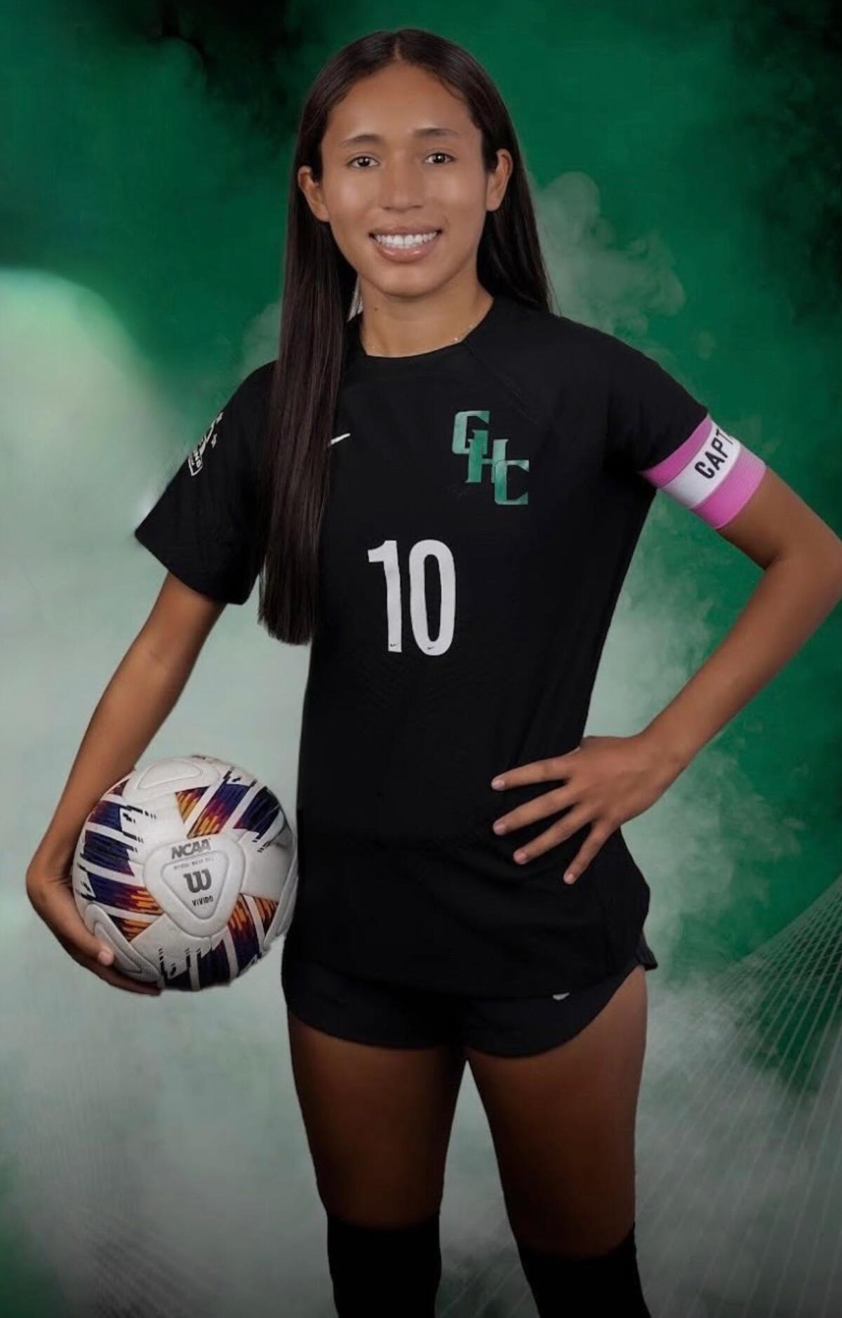 Ana De Los Santos of Granada Hills High poses for a photo while holding a soccer ball in her right hand by her hip.