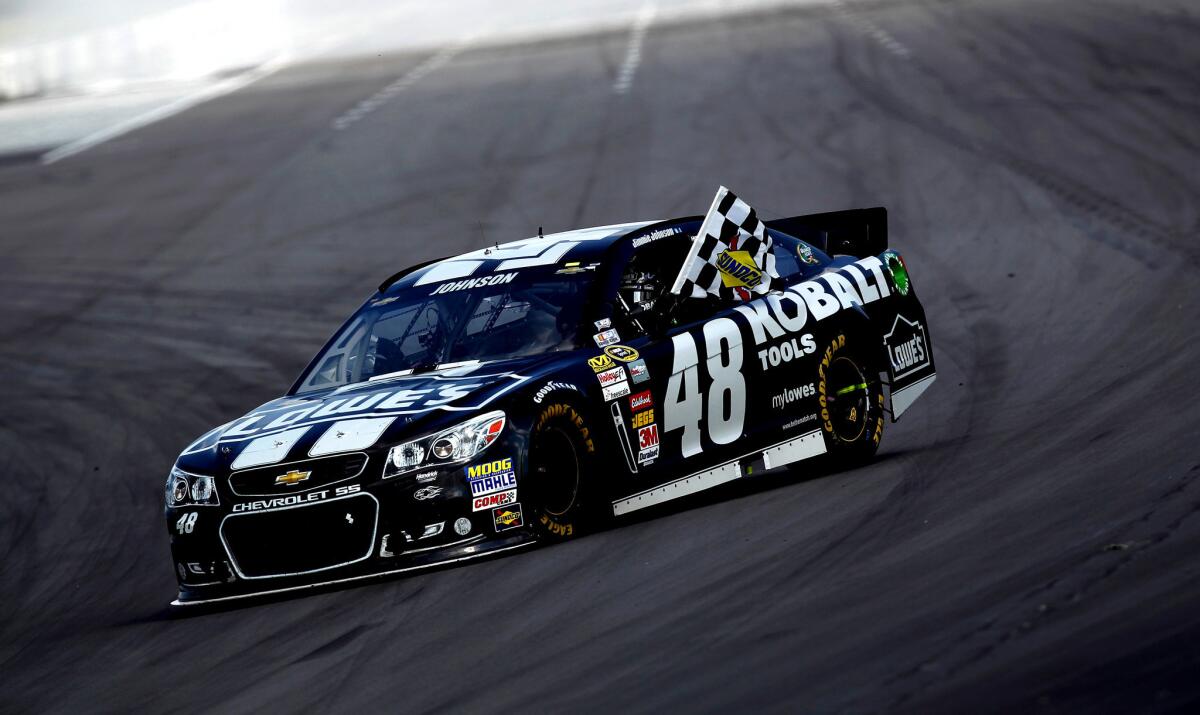 Jimmie Johnson celebrates with the checkered flag after winning the Party in the Poconos 400 at Pocono Raceway.