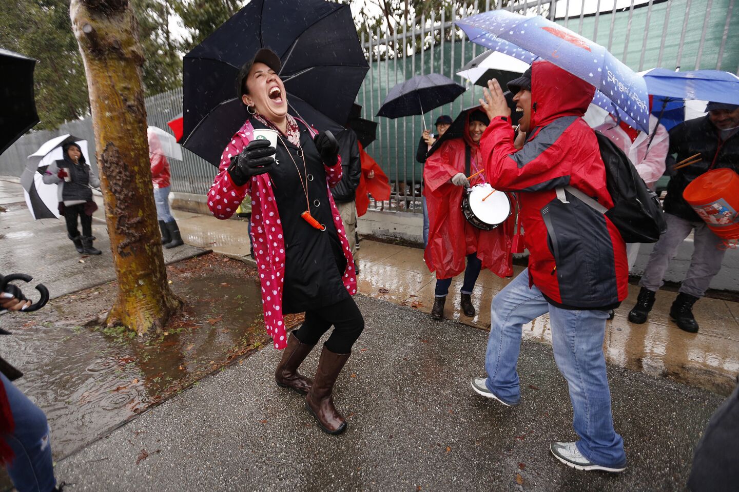 Anavelia Valencia, left, and Courtney Moore, right, teachers at 99th Street Elementary school, perform a "rain dance" on the picket line in South Los Angeles.