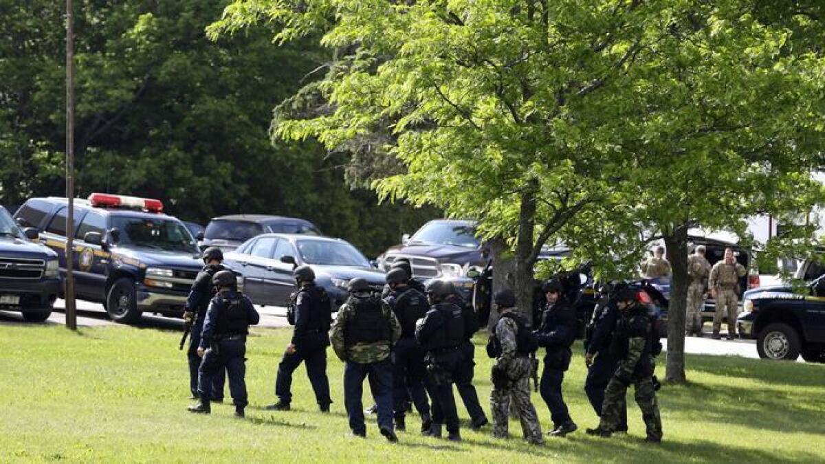 Oficiales de la policía fuertemente armados se preparan el 11 de junio de 2015, para reanudar la búsqueda de dos asesinos fugados cerca de Dannemora, N.Y.
