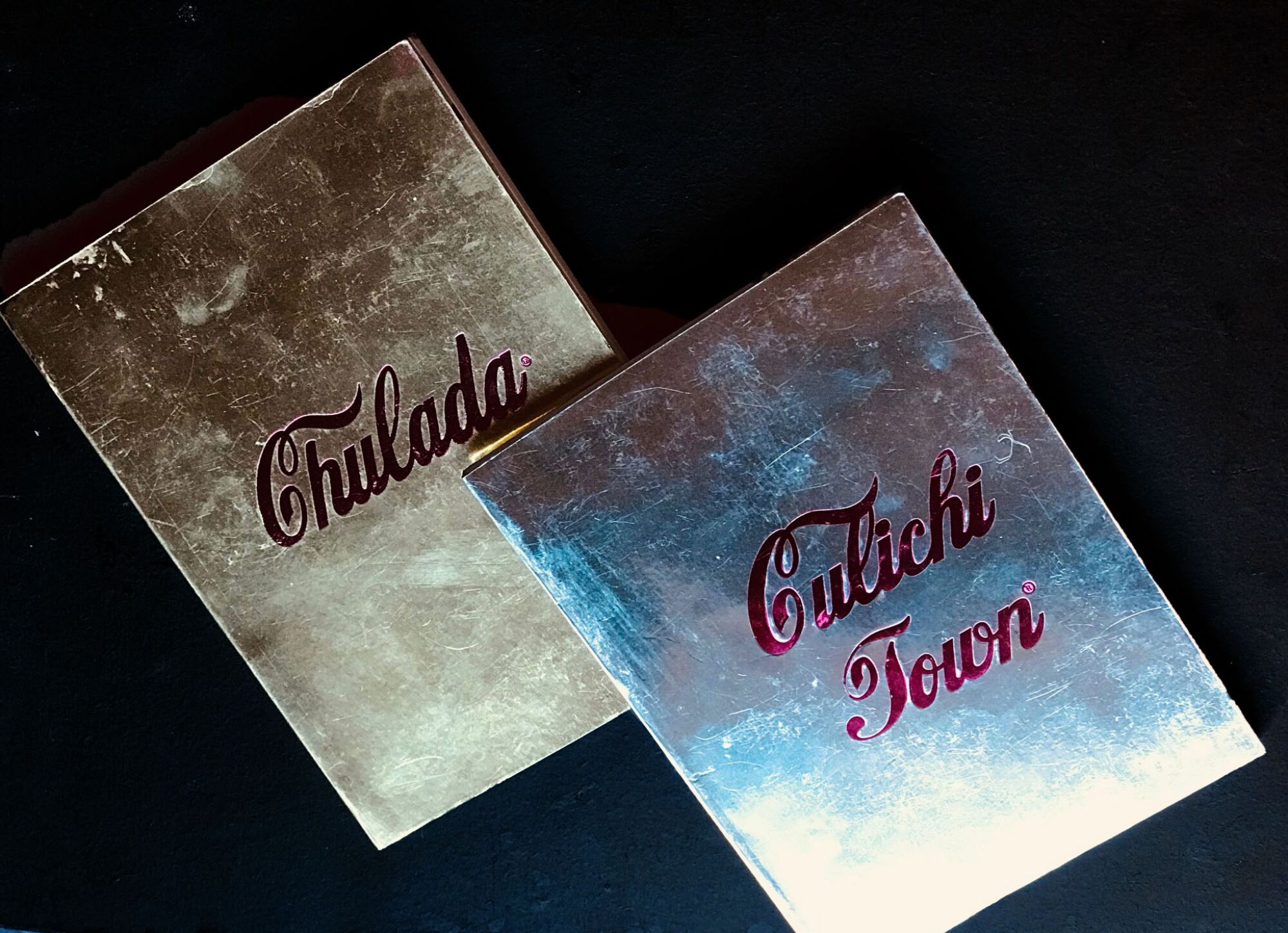 Two book covers in gold for "Chulada" and "Culichitown" feature their titles in red, cursive script.
