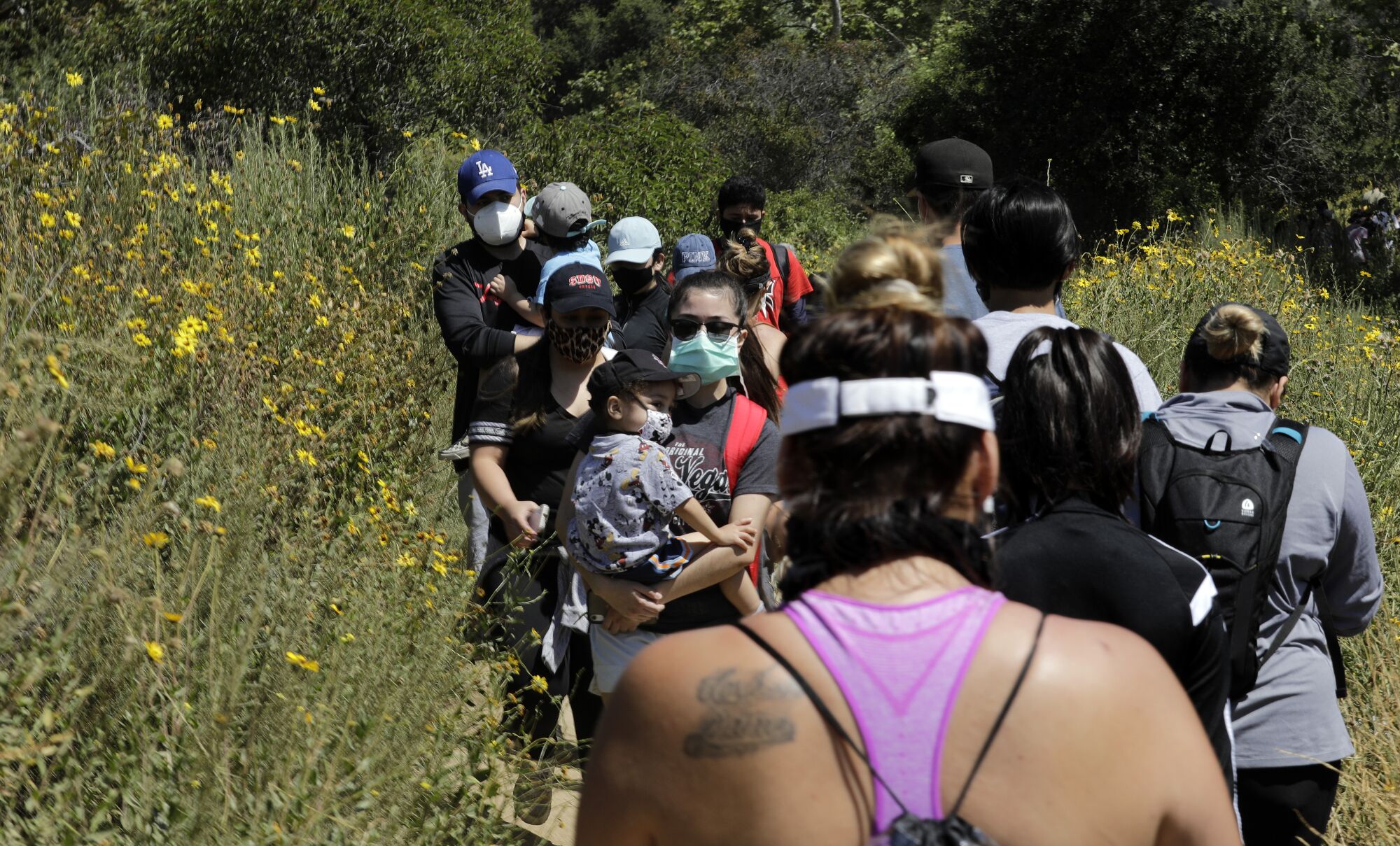 Visitors share a narrow hiking path at Eaton Canyon Natural Area Park on May 24.