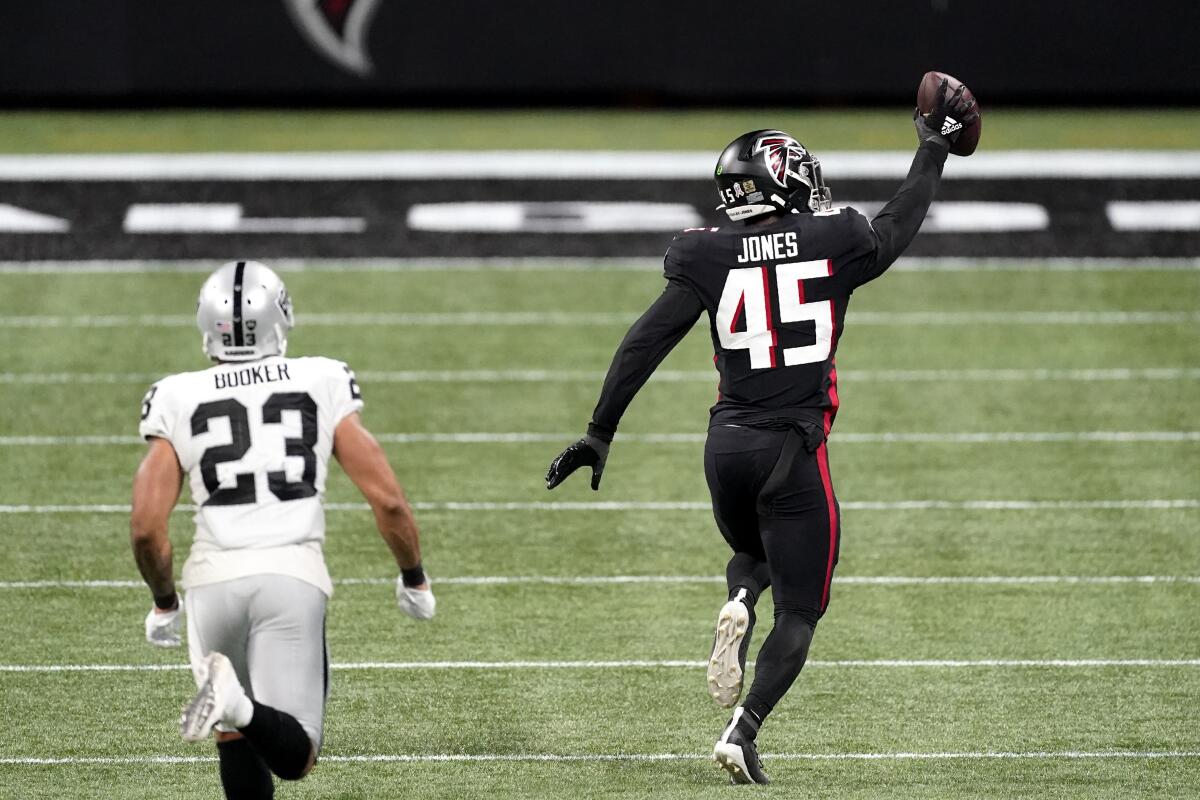 Atlanta Falcons linebacker Deion Jones runs toward the end zone for a touchdown after intercepting a pass.