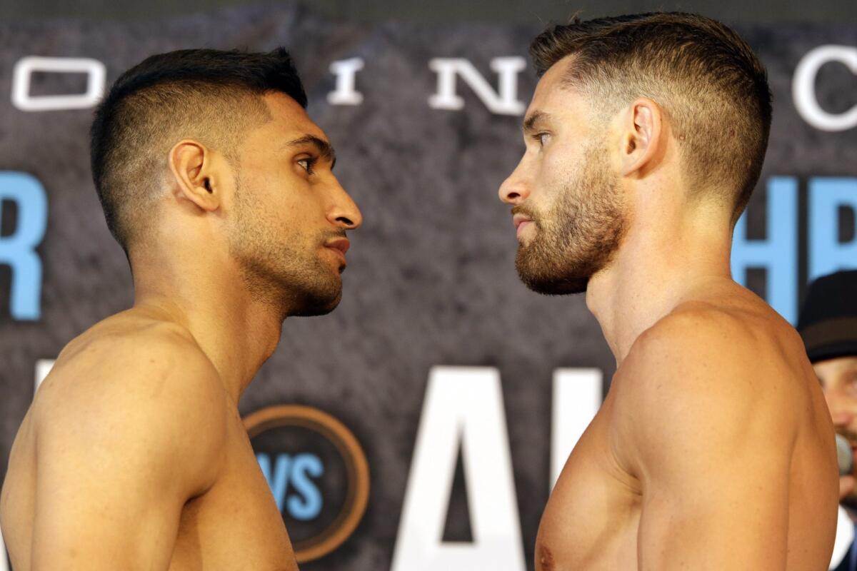 Amir Khan, left and Chris Algieri pose for photographers Thursday while weighing in for their welterweight bout Friday night in Brooklyn.