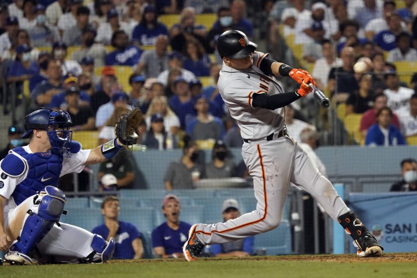 San Francisco Giants' Wilmer Flores connects for a two-run home run during the ninth inning of the team's baseball game against the Los Angeles Dodgers on Wednesday, July 21, 2021, in Los Angeles. (AP Photo/Marcio Jose Sanchez)