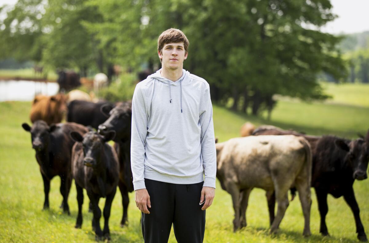 Lakers guard Austin Reaves, nicknamed "Hillbilly Kobe" in college, stands in a field at his family's cattle farm.
