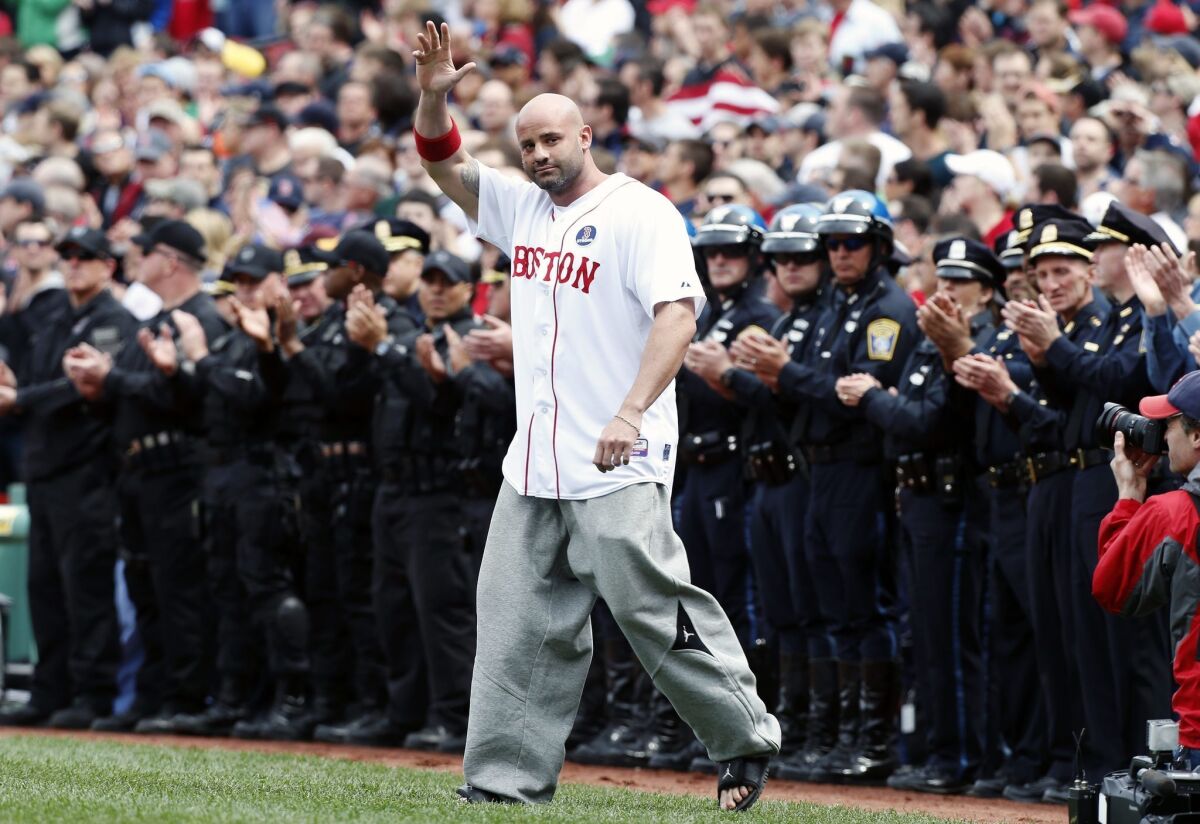 Boston Marathon bombing victim Steven Byrne waves as he comes onto the field at fenway for a ceremonial first pitch before Saturday's game between the Boston Red Sox and the Kansas City Royals in Boston.