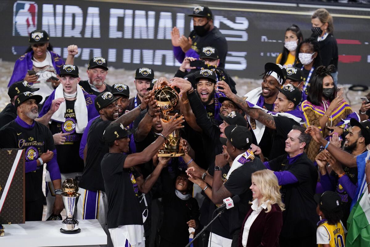 The Lakers celebrate with the Larry O'Brien Trophy as NBA champions on Sunday night.