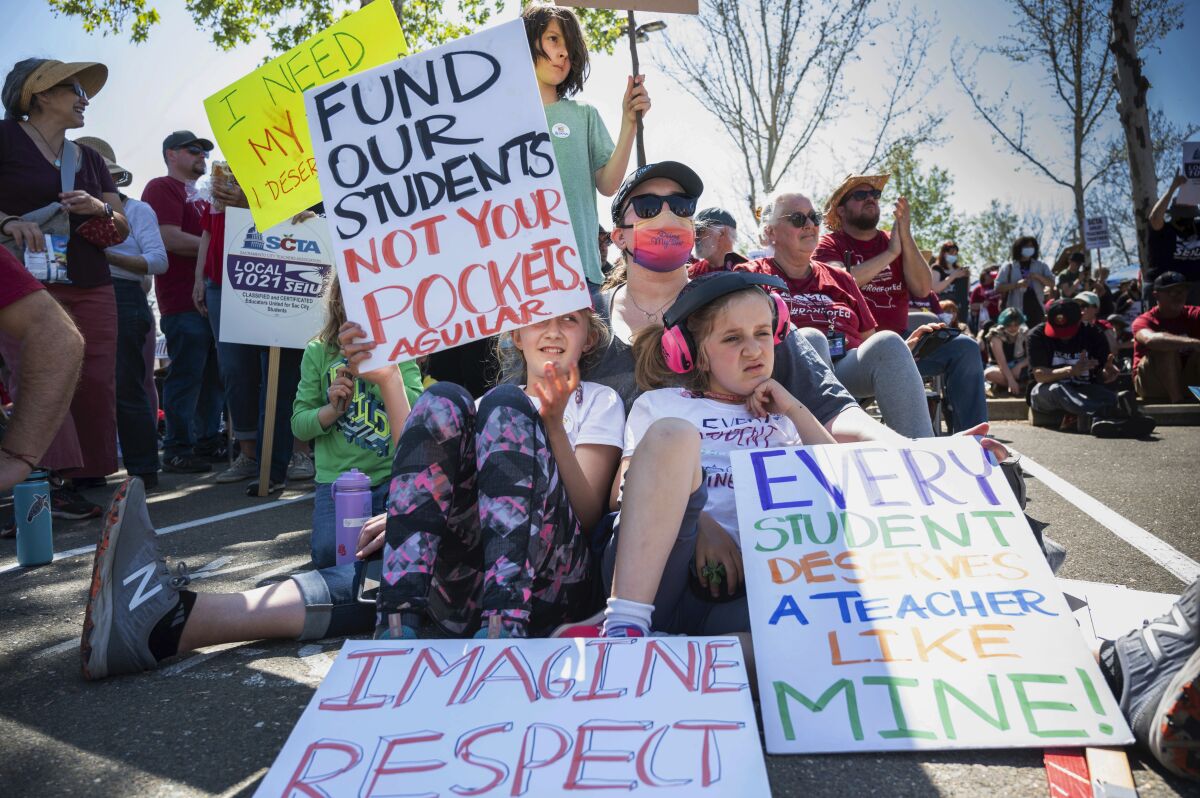  Striking Sacramento teachers hold picket signs 