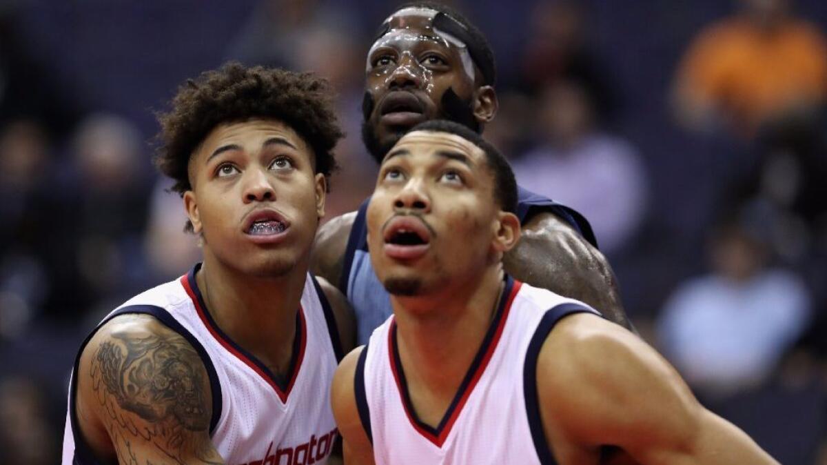 Washington forwards Kelly Oubre and Otto Porter Jr., right, box out Memphis forward JaMychal Green during a game on Jan. 18.