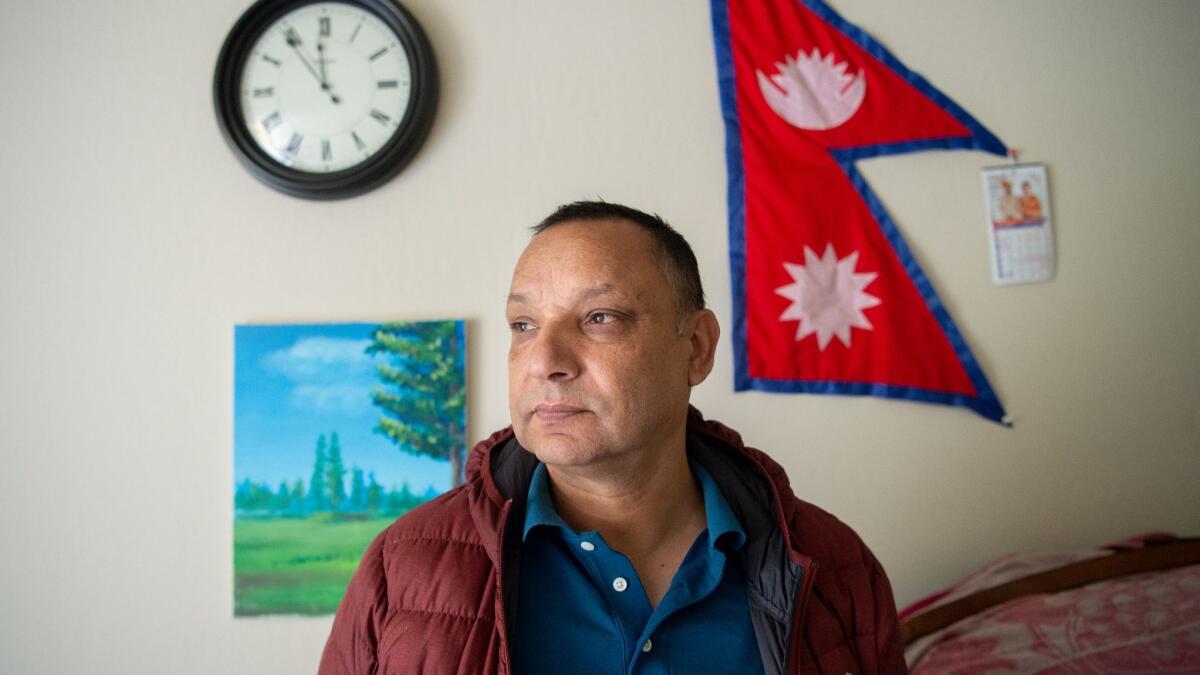 A Nepalese flag hangs on the wall behind Keshav Bhattarai at his home in Sunnyvale, Calif., on Feb. 24, 2019.