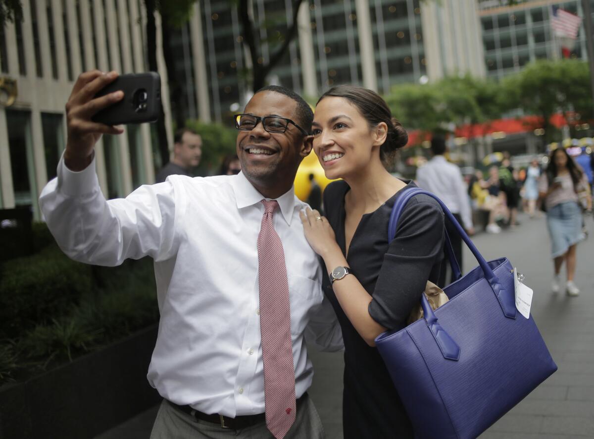 Alexandria Ocasio-Cortez takes a selfie with a man in New York.