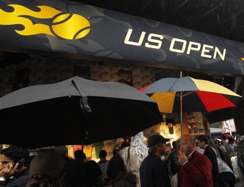 Tennis fans wait during a rain delay before the start of the men's championship match at the U.S. Open tennis tournament in New York, Sunday, Sept. 12, 2010.(AP Photo/Mike Groll)