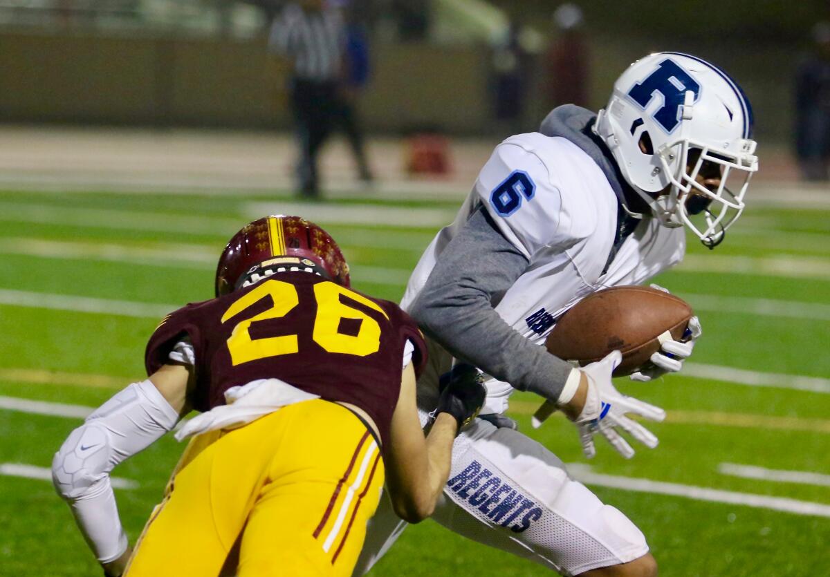 Reseda wide receiver Mario Martinez, right, shakes a tackle attempt by Esperanza cornerback Coby Hoke in Saturday’s game.