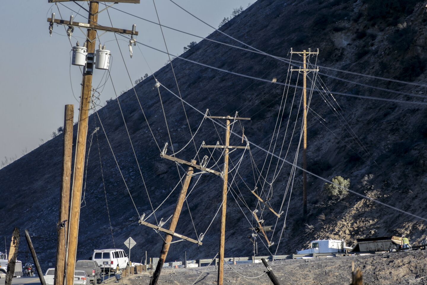 Work crew prepare to repair downed power lines damaged by the Blue Cut fire on Highway 138 at the junction of 15 Freeway.