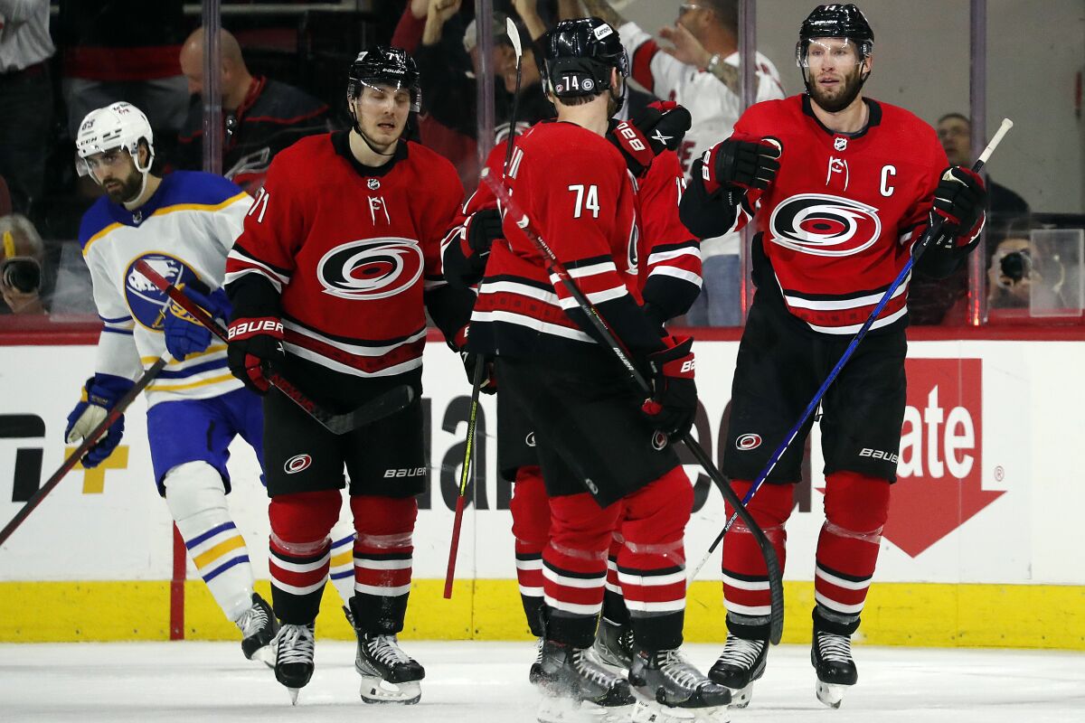 Carolina Hurricanes' Jordan Staal, right, celebrates his empty-net goal with teammates as Buffalo Sabres' Alex Tuch (89) skates past during the third period of an NHL hockey game in Raleigh, N.C., Thursday, April 7, 2022. (AP Photo/Karl B DeBlaker)