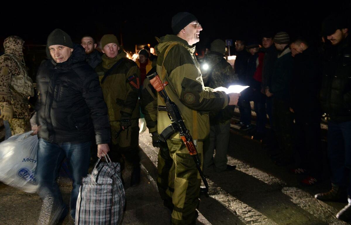 Armed supporters of the self-declared People's Republic of Donetsk oversee their end of a prisoner exchange with the Ukrainian government on Friday.