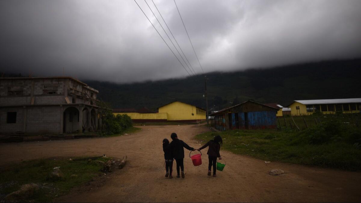 Kids play while adults attend the wake of Felipe Gomez, the eight-year-old migrant who died in the custody of the U.S. border patrol, in Yalambojoch, Guatemala on Jan. 26.