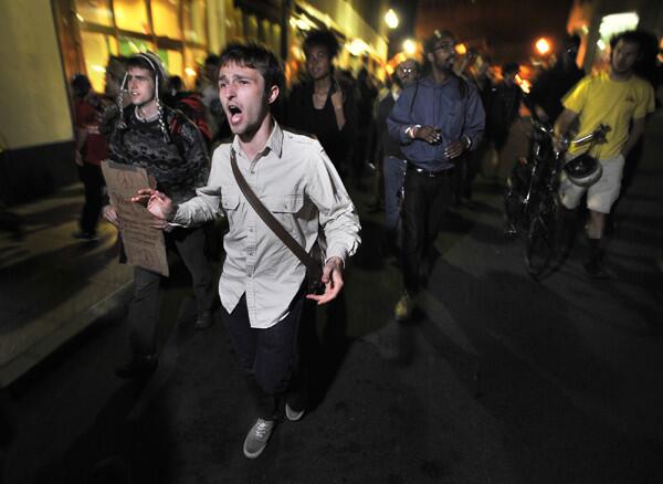 Demonstrators with "Occupy Boston" march toward the police station where fellow demonstrators were brought after police arrested people sleeping in an expansion of the Occupy Boston tent village in Boston, in the early morning hours Tuesday.