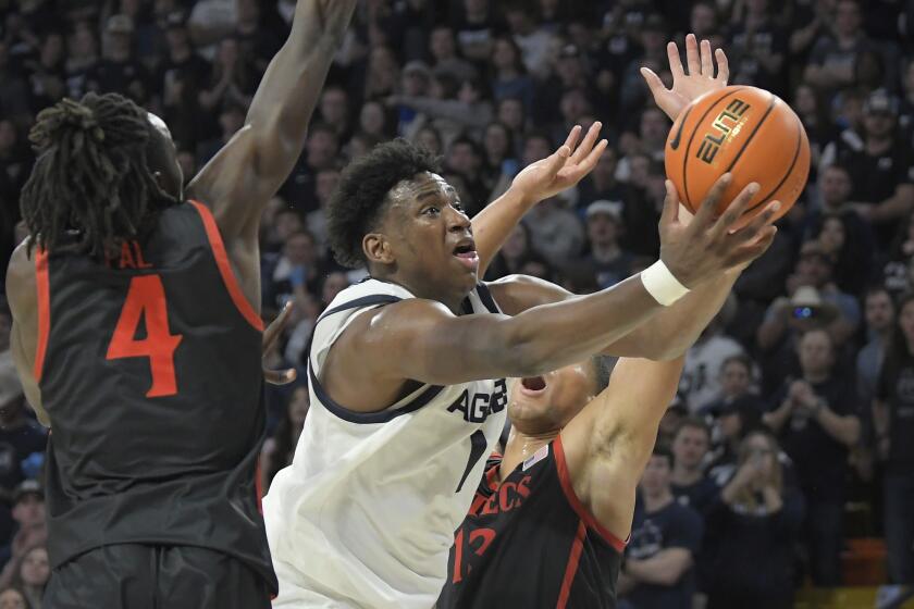 Utah State forward Great Osobor (1) shoots the ball as San Diego State forward Jay Pal (4) and forward Jaedon LeDee defend during the second half of an NCAA college basketball game Tuesday, Feb. 20, 2024, in Logan, Utah. (Eli Lucero/The Herald Journal via AP)
