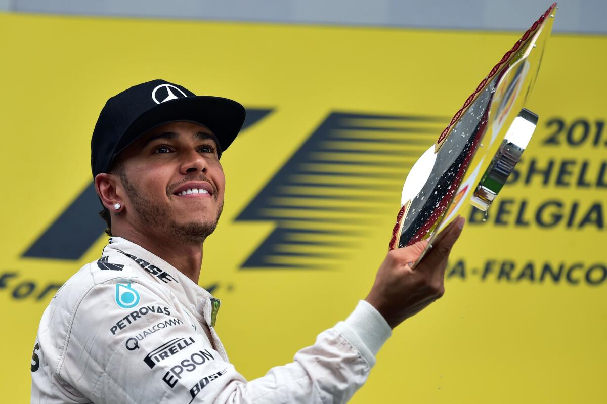 Formula One driver Lewis Hamilton celebrates with the trophy on the podium after winning the Belgian Grand Prix on Sunday.