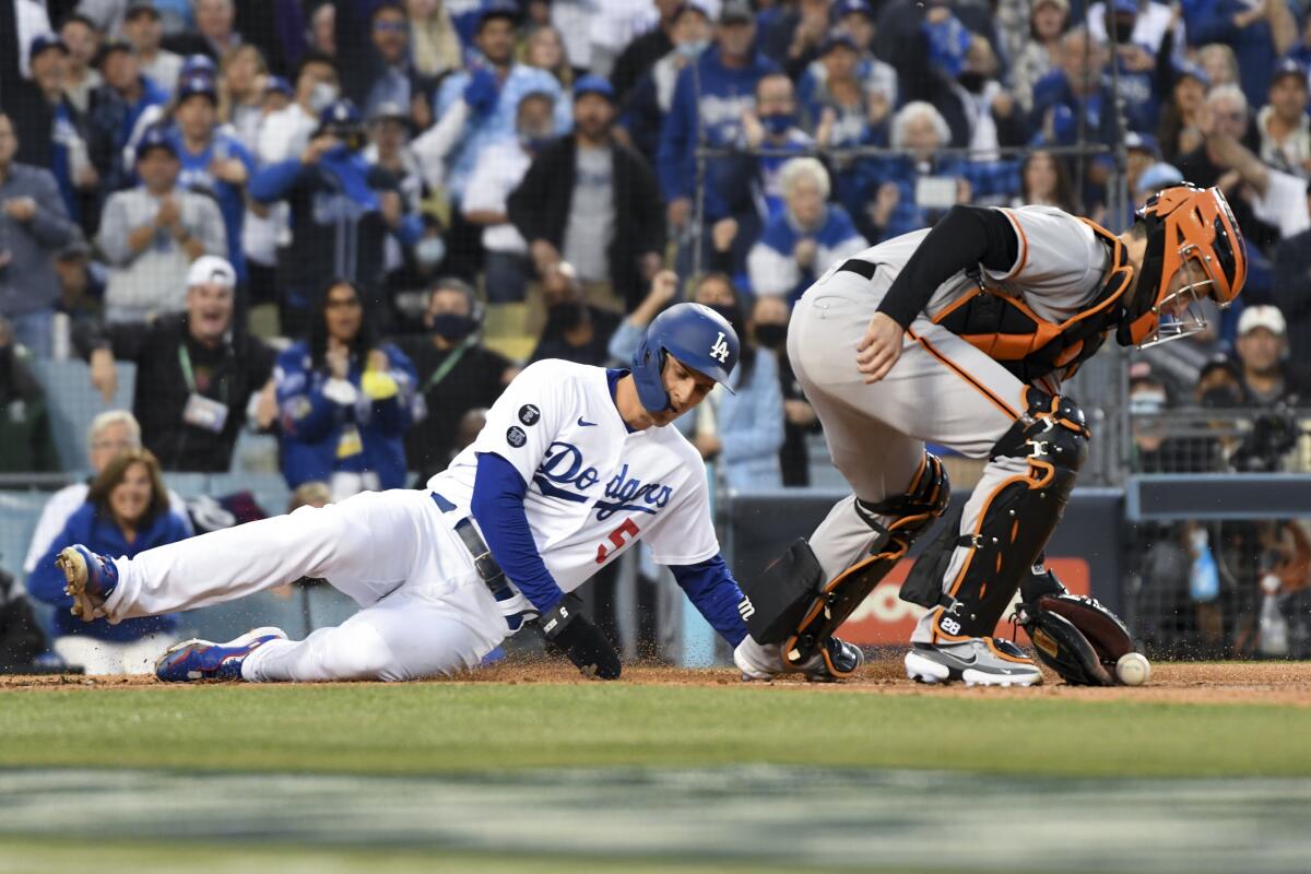 Dodgers baserunner Corey Seager scores past San Francisco Giants catcher Buster Posey.