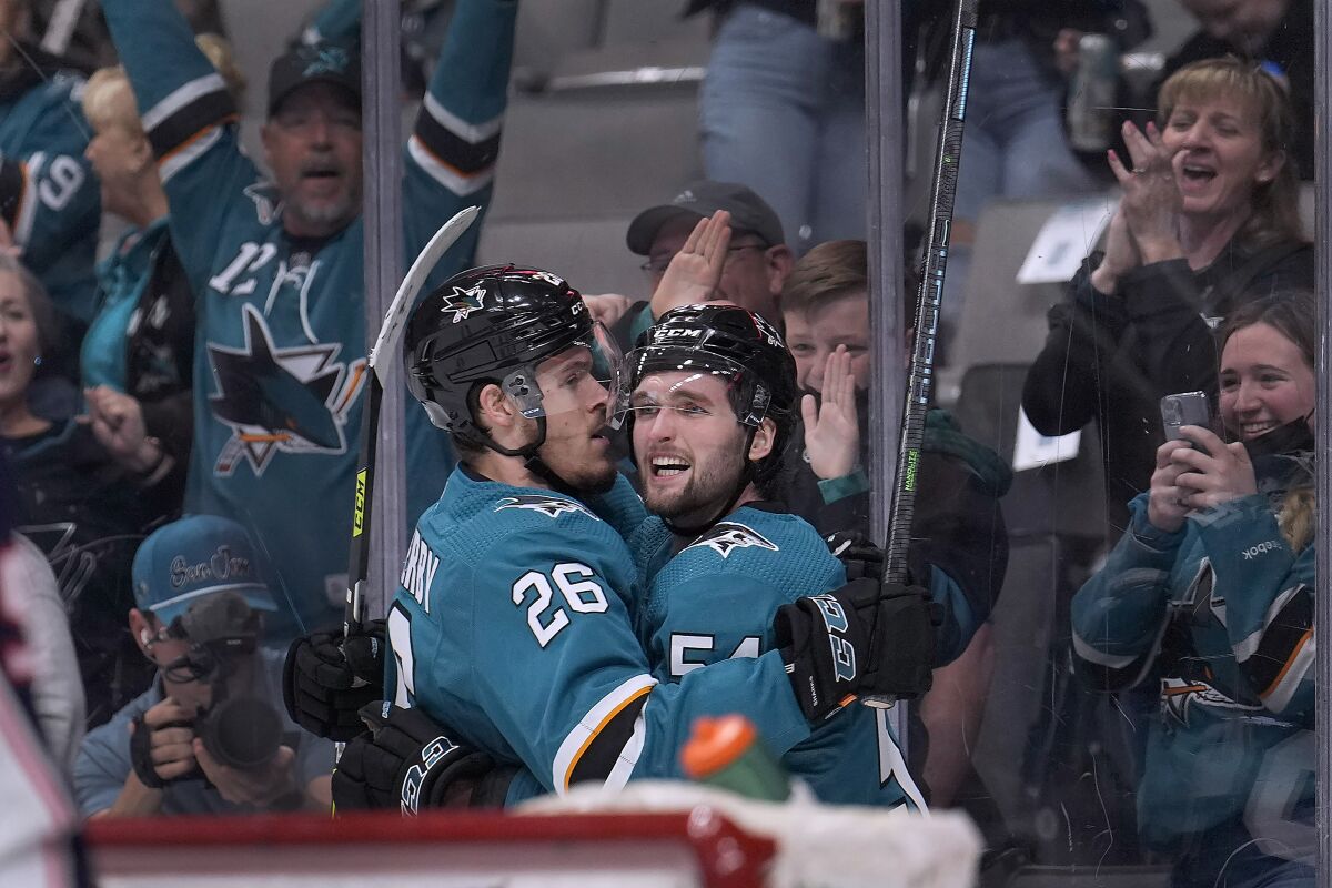 San Jose Sharks center Scott Reedy (54) celebrates with Jasper Weatherby (26) after scoring a goal against the Columbus Blue Jackets during the first period in an NHL hockey game Tuesday, April 19, 2022, in San Jose, Calif. (AP Photo/Tony Avelar)