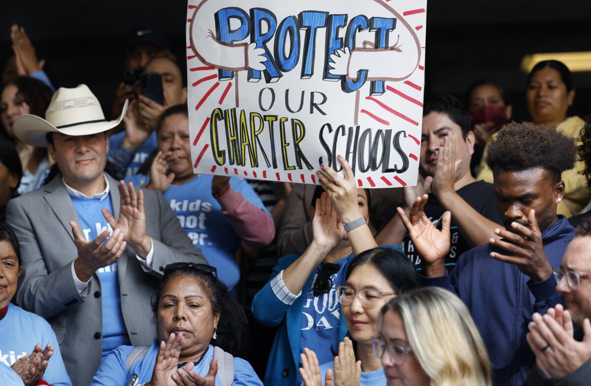 Charter school supporters clapping hands and holding signs