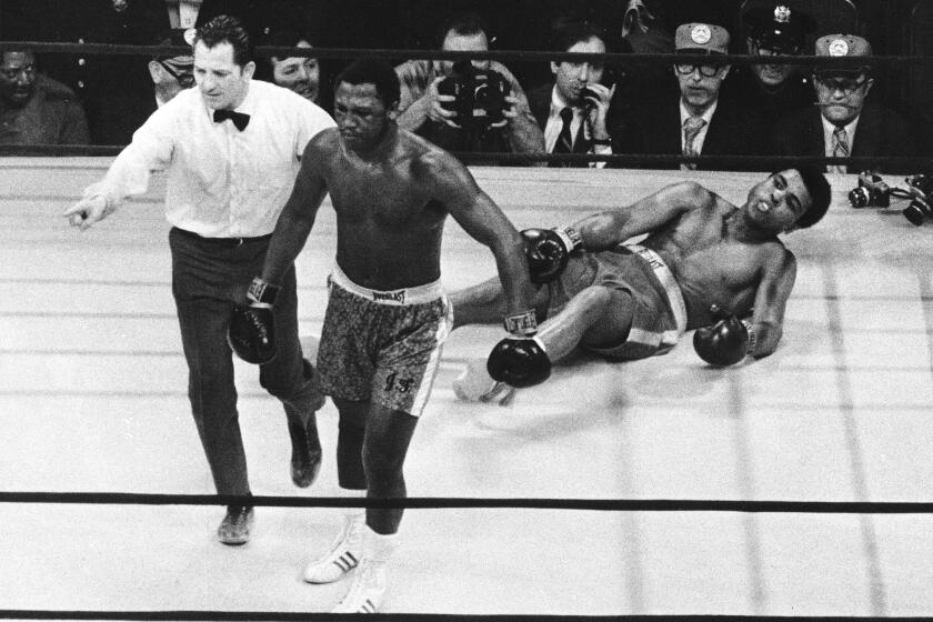 FILE - In this March 8, 1971, file photo, boxer Joe Frazier is directed to his corner by referee Arthur Marcante.