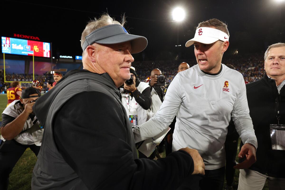 UCLA coach Chip Kelly, left, shakes hands with USC coach Lincoln Riley after the Trojans' 48-45 win.