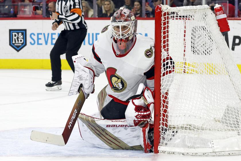 Ottawa Senators goaltender Cam Talbot squats and watches the puck move during a game