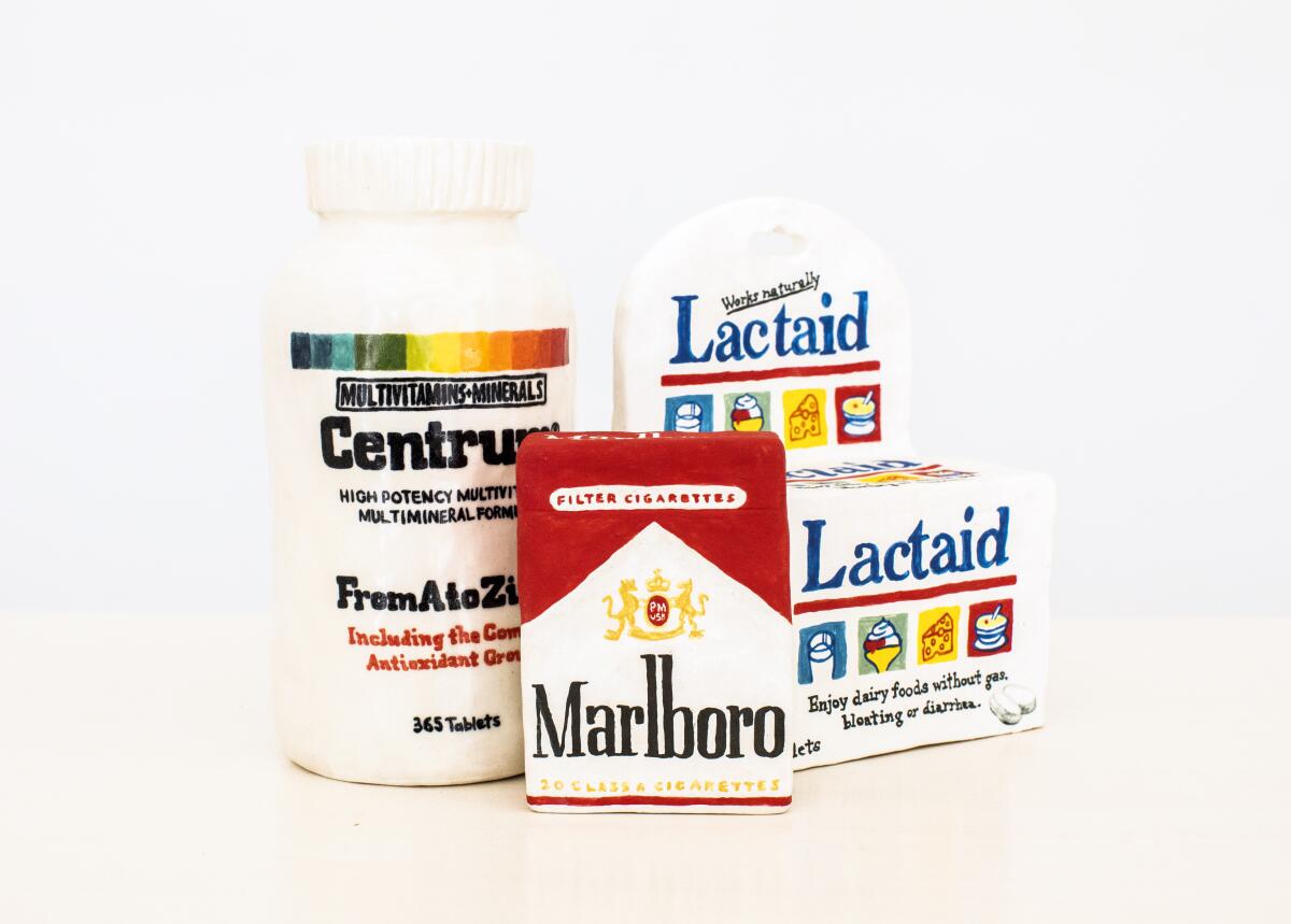Ceramic art pieces mimic a bottle of vitamins, a pack of cigarettes and Lactaid.