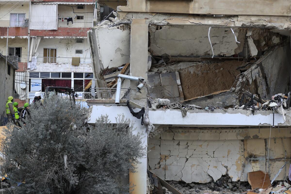 Rescatistas y operarios de defensa civil retiran los escombros de un edificio alcanzado