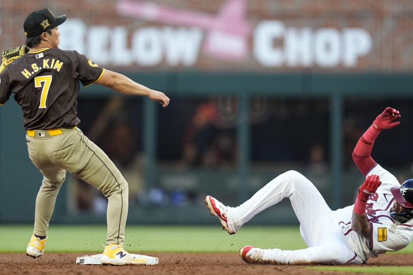 Atlanta Braves' Orlando Arcia (11) is tagged out at second base by San Diego Padres shortstop Ha-Seong Kim (7) in the second inning of a baseball game, Sunday, May 19, 2024, in Atlanta. (AP Photo/Mike Stewart)