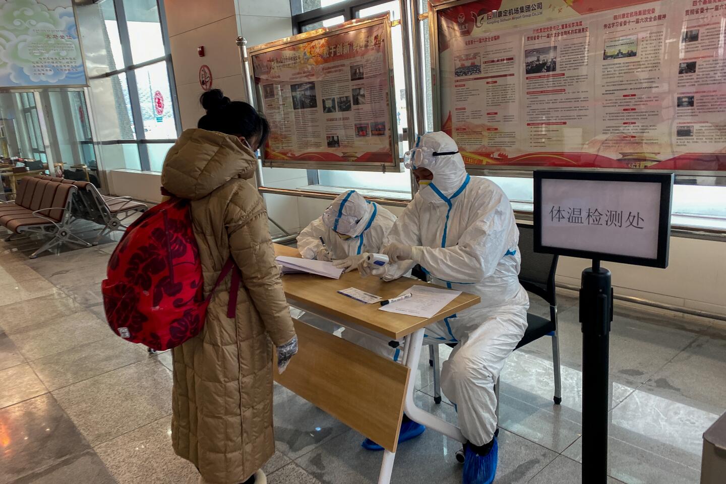 Medical workers checked travelers' temperatures at Garze airport on Feb. 15, 2020.